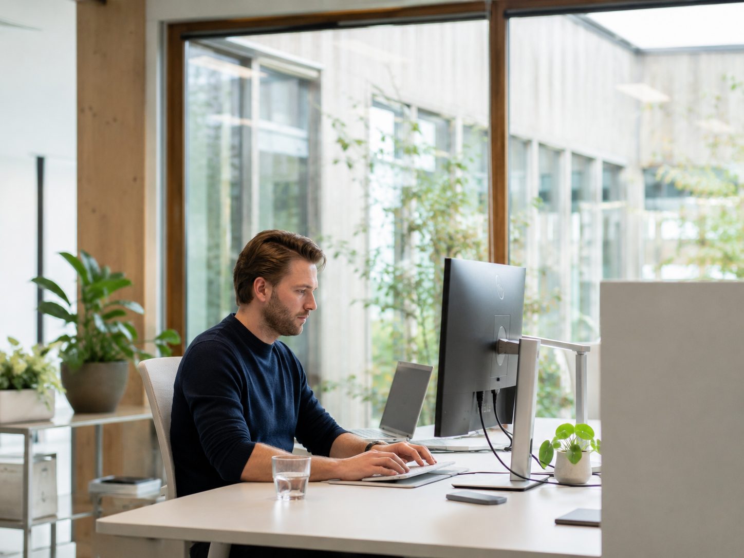 Medewerker die geconcentreerd aan een digitale werkplek werkt.