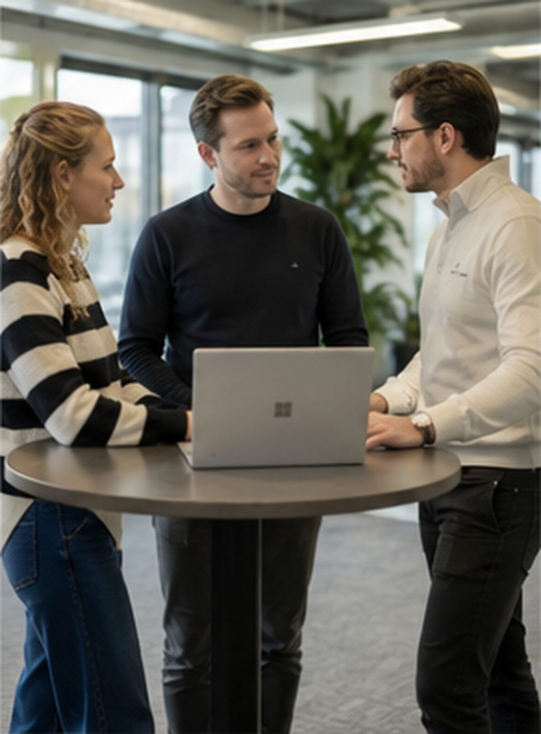 Collega’s in overleg aan een hoge tafel.