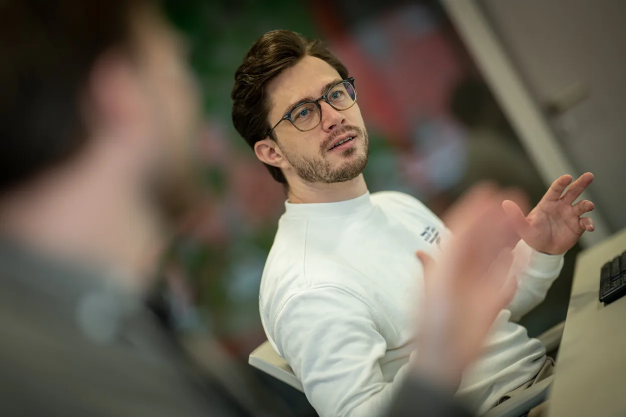 Collega in gesprek tijdens een werksessie.