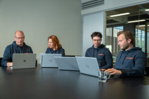 Collega's ervaren samen de voordelen van Microsoft 365 tijdens hun werk op laptops
